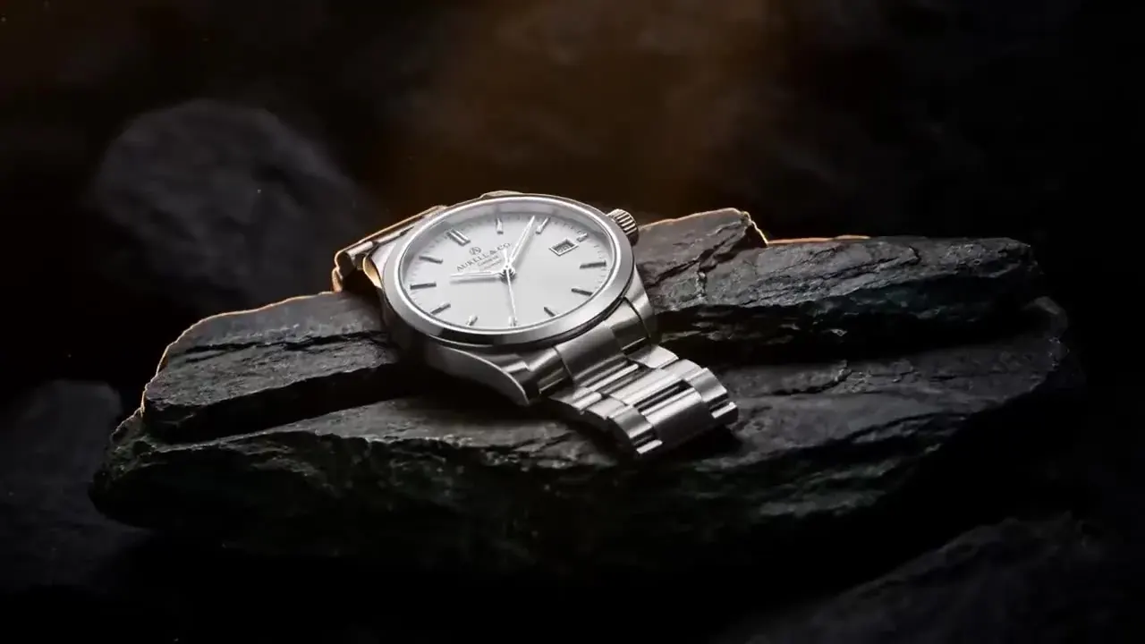 Wan 2.5 product recipe illustration: a steel wristwatch resting on dark slate in a moody studio