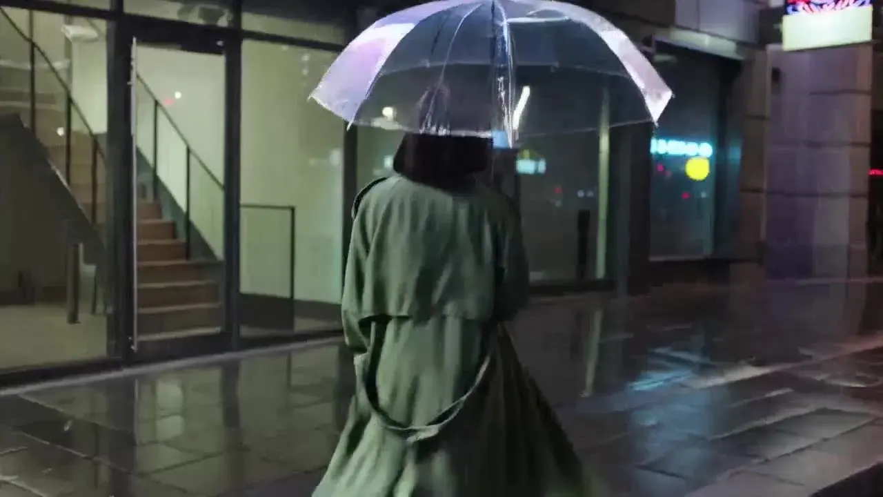 Illustration for the Kling 3.0 slot: the woman in the green trench coat looking up into the rain under her umbrella